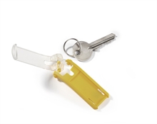 Nyckelbricka i gult med namnbeteckning med öppen skyddande plasthölje.