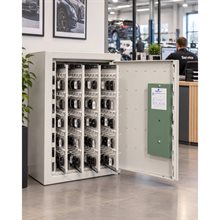 Ljusgrått nyckelskåp med öppen dörr, fyllt med bilnycklar på numrerade krokar, i en bilserviceverkstad.