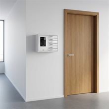 Vitt väggmonterat nyckelskåp med digitalt kodlås och sex fack, i kontorsmiljö bredvid en trädörr.
