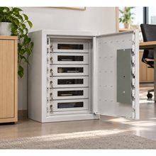 Vitt värdeskåp med öppen dörr, sex transparenta låsbara fack med nycklar och innehåll, i kontorsmiljö.